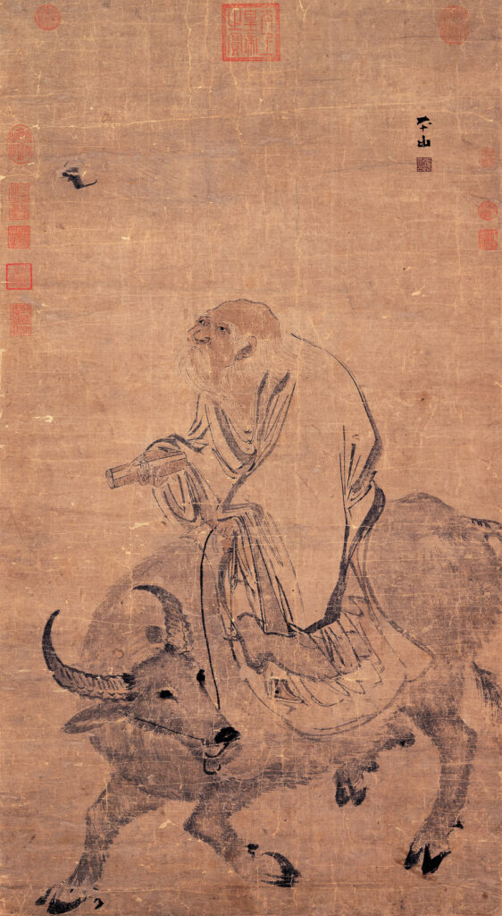 Ink painting by Zhang Lu of an elderly Laozi seated on the back of an ox, reading a scroll, brushed in loose Ming dynasty strokes. National Palace Museum, Taipei.