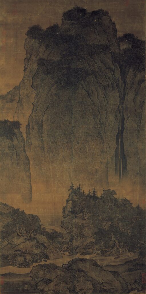 Fan Kuan's hanging scroll Travelers Among Mountains and Streams: a sheer cliff filling the upper two thirds of the silk, with a mule train barely visible on the path below. National Palace Museum, Taipei.