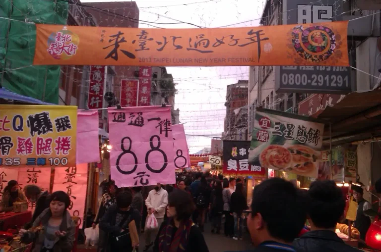 Crowds buying New Year goods beneath festival banners on Dihua Street in Taipei